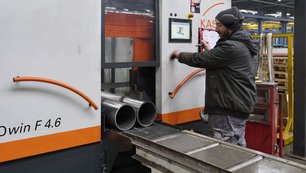 Automated cutting machine processing steel pipes to specified lengths at Royal Van Leeuwen